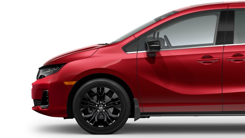 Plan latéral de l’avant d’une Odyssey rouge sur fond blanc, montrant sa roue avant noire.