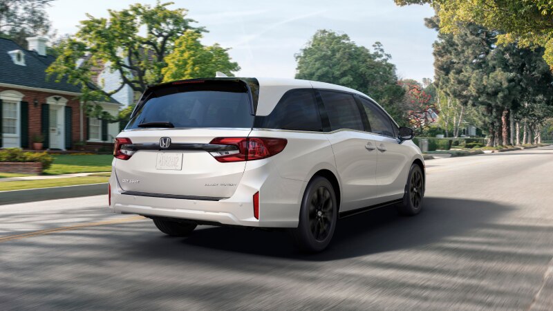 Vue latérale d’une Odyssey blanche stationnée au bord d’un lac.