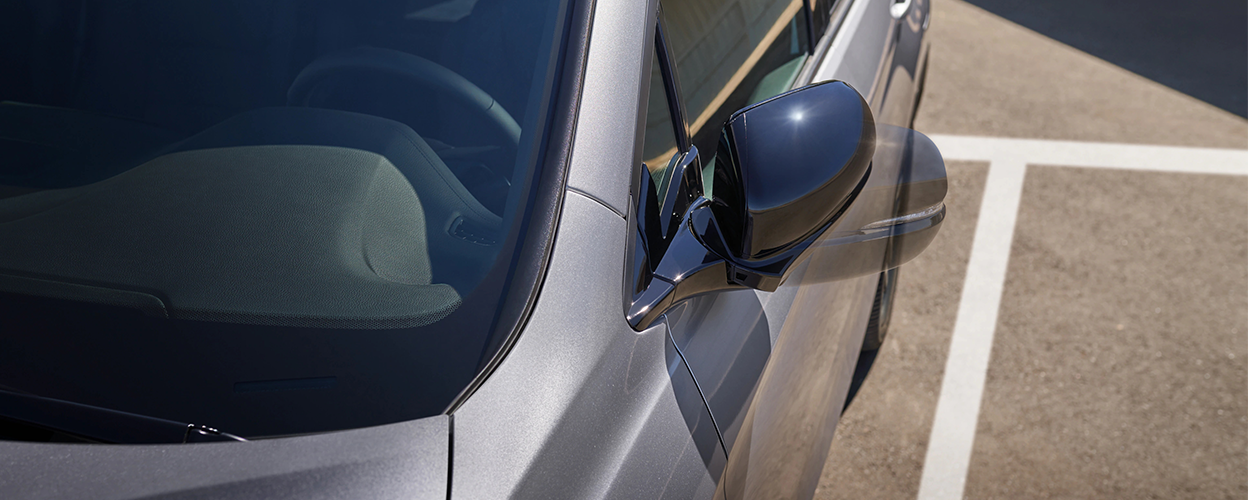 Closeup of side mirror on grey Honda Passport.