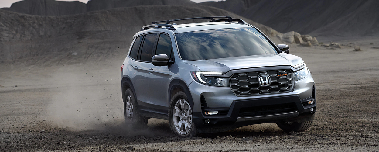 3/4 front view of grey Honda Passport off-roading in desert.