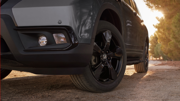 Closeup of wheel on black Honda Passport.