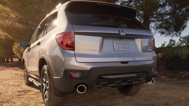 3/4 rear closeup of grey Honda Passport in forest.