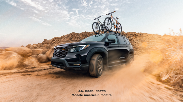 3/4 side front view of black Passport desert off-roading with two bikes on the roof rails.