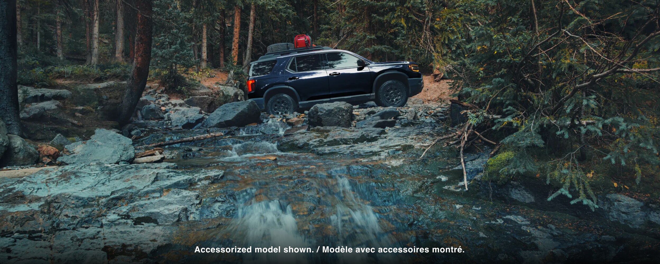 A black Passport drives over rough mountain terrain. 