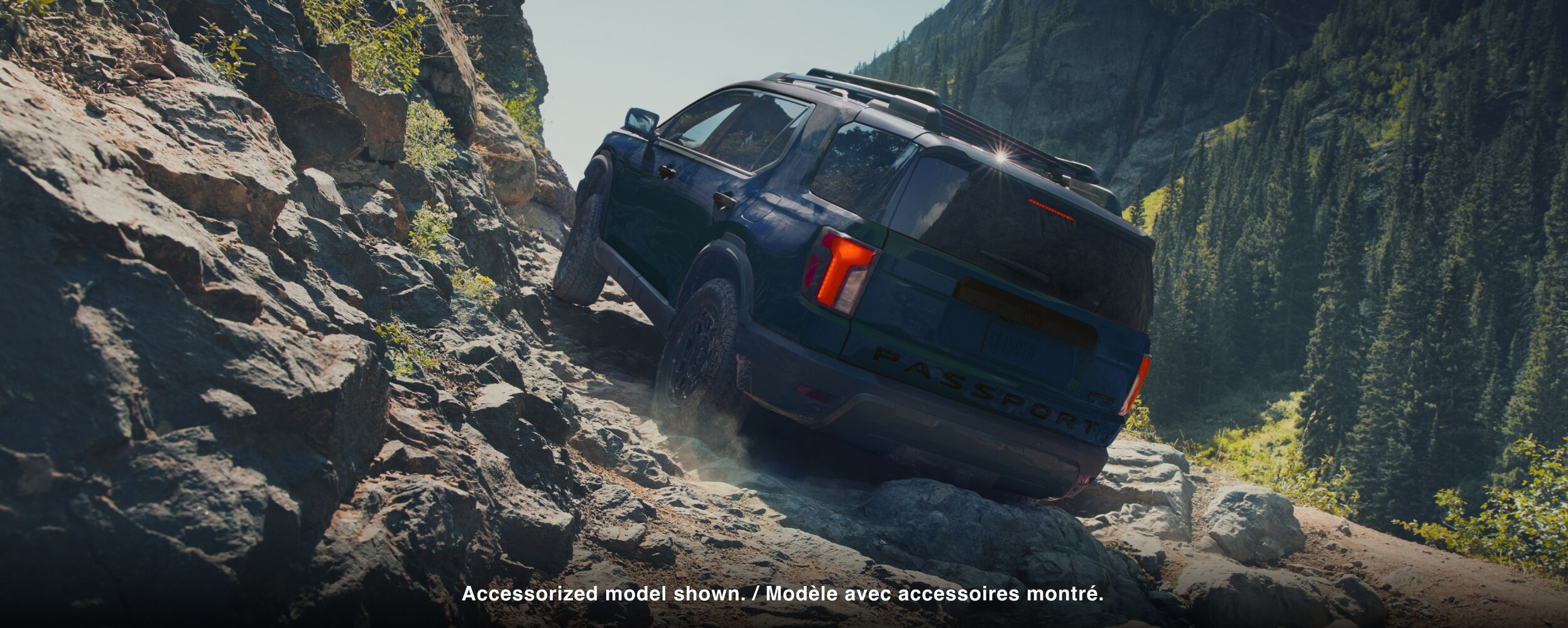 A black Passport drives over rough mountain terrain. 