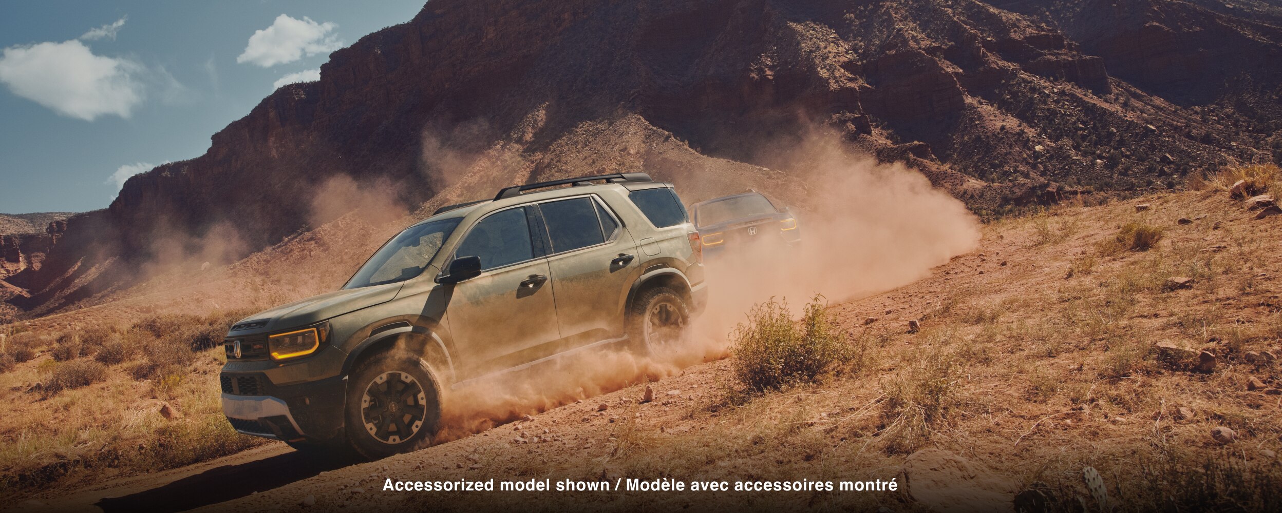 A green Passport drives through dusty desert terrain. 