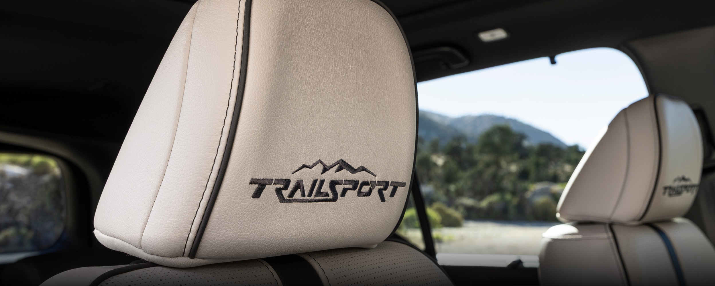 Plan des sièges avant du Passport TrailSport Touring Blackout, avec coutures noir et logo « TrailSport » sur les appuie-tête