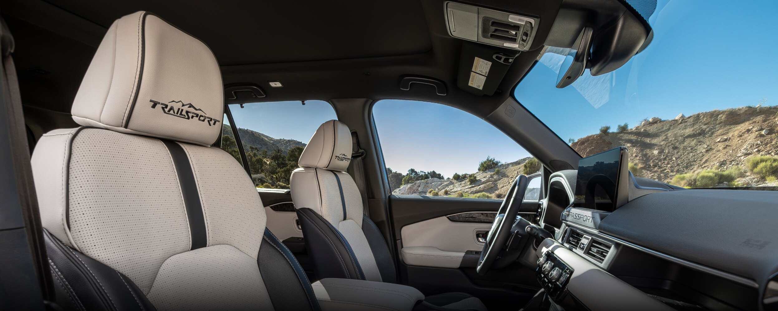 View of front seats on Passport TrailSport Touring Blackout, showcasing the front seat’s black stitching and “TrailSport” logo on headrests.