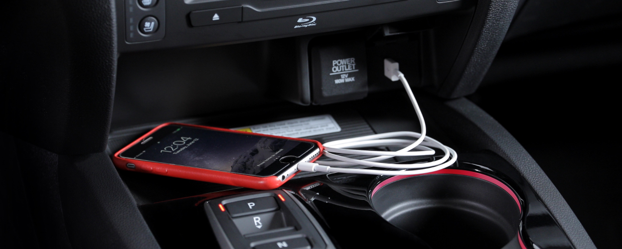 Close up of centre console, phone charging on USB outlet.