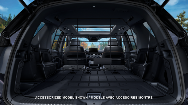 Straight-on view of tailgate open showcasing the vast cargo space with 2nd and 3rd-row seats flat-folded down.