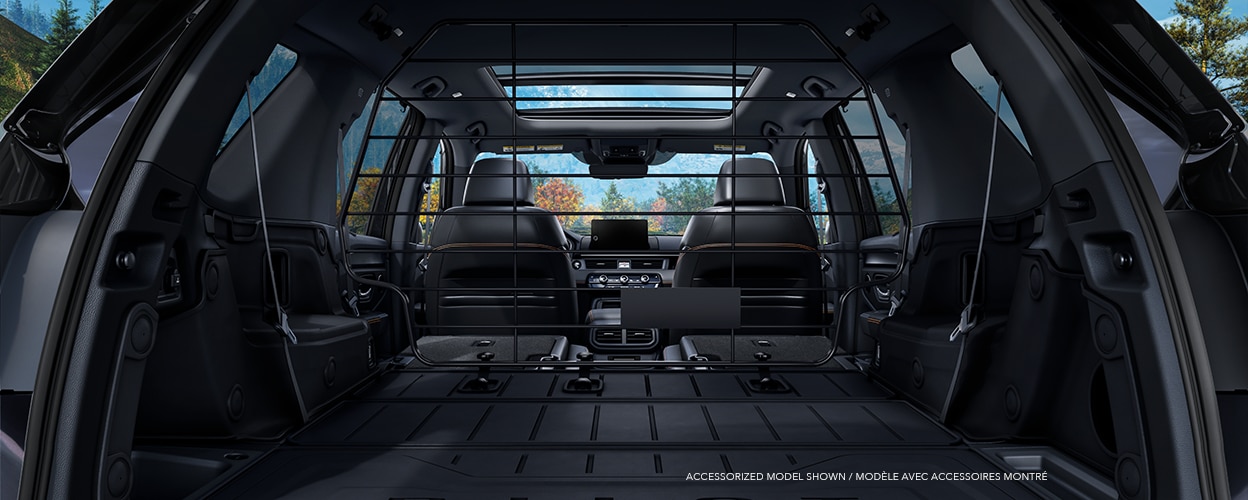 Straight-on view of tailgate open showcasing the vast cargo space with 2nd and 3rd-row seats flat-folded down.