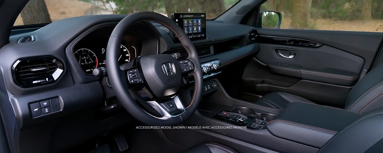 Driver’s side view of steering wheel, front seats, and front dashboard.