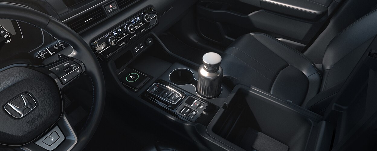 honda pilot 3/4 interior bird’s eye view showcasing the front row and centre console, with a water bottle in the cupholder. 