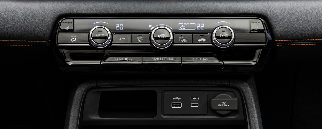 Gros plan des commandes de climatisation sur la console centrale.
