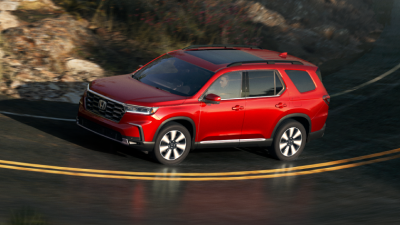 Plan de trois quarts latéral d’un Pilot rouge en virage sur une autoroute.