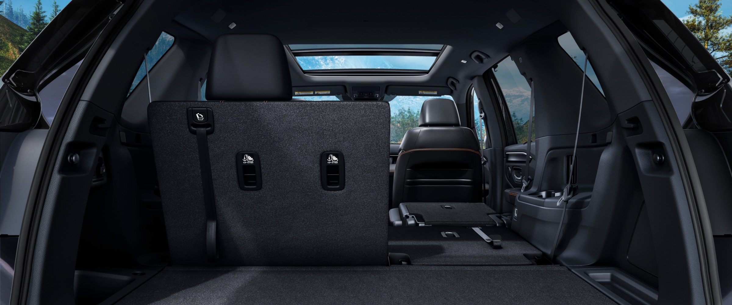 Rear view of the Pilot's interior from the open trunk, with part of the second-row seats folded down to highlight versatility.