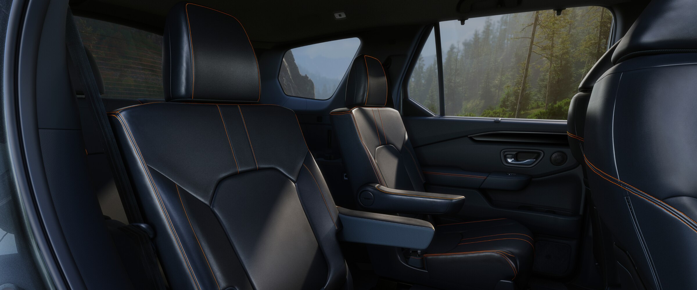 Vue intérieure de la deuxième rangée du Pilot avec deux sièges capitaines vus de la portière côté passager. 