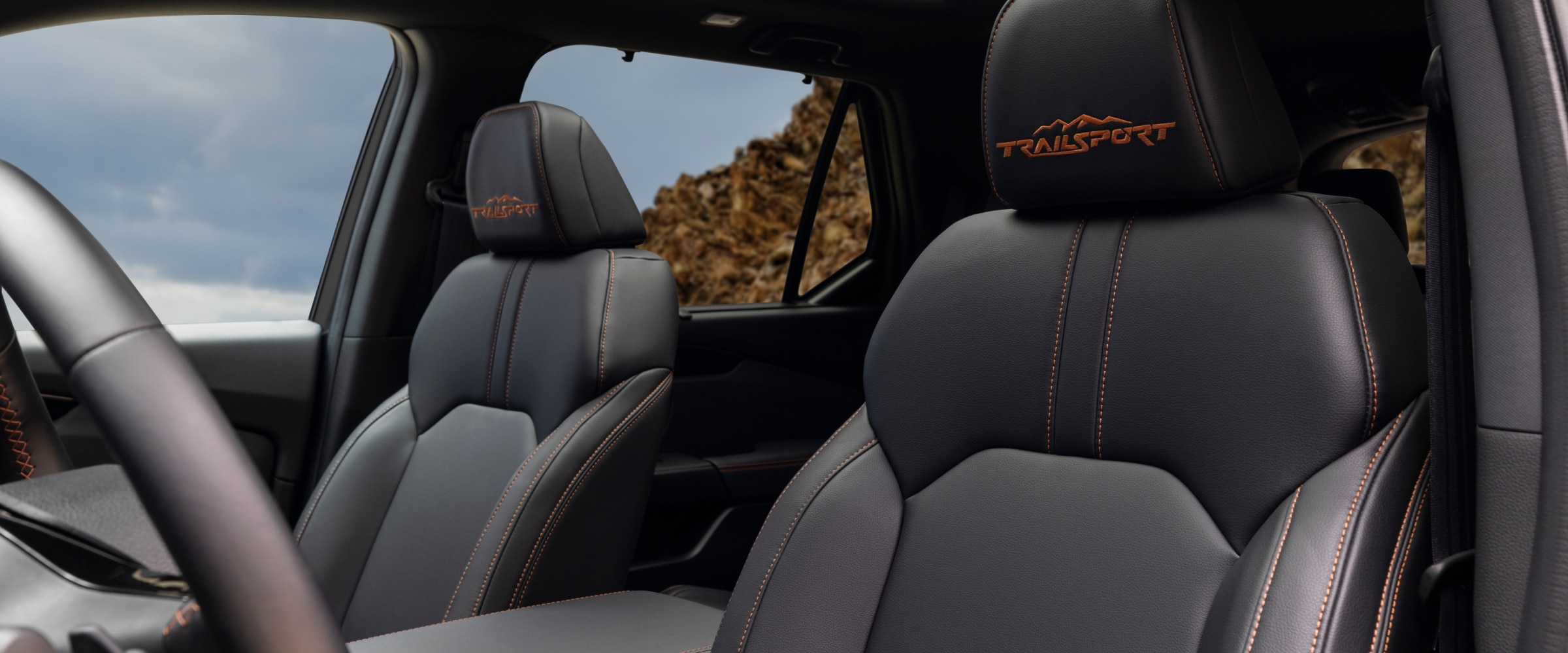 Interior view of the Pilot Trailsport's front-row seats, featuring "Trailsport" in orange stitching.