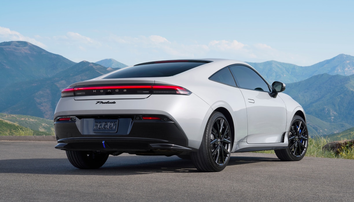 3/4 rear side view of a white Prelude parked in front of a mountain backdrop.