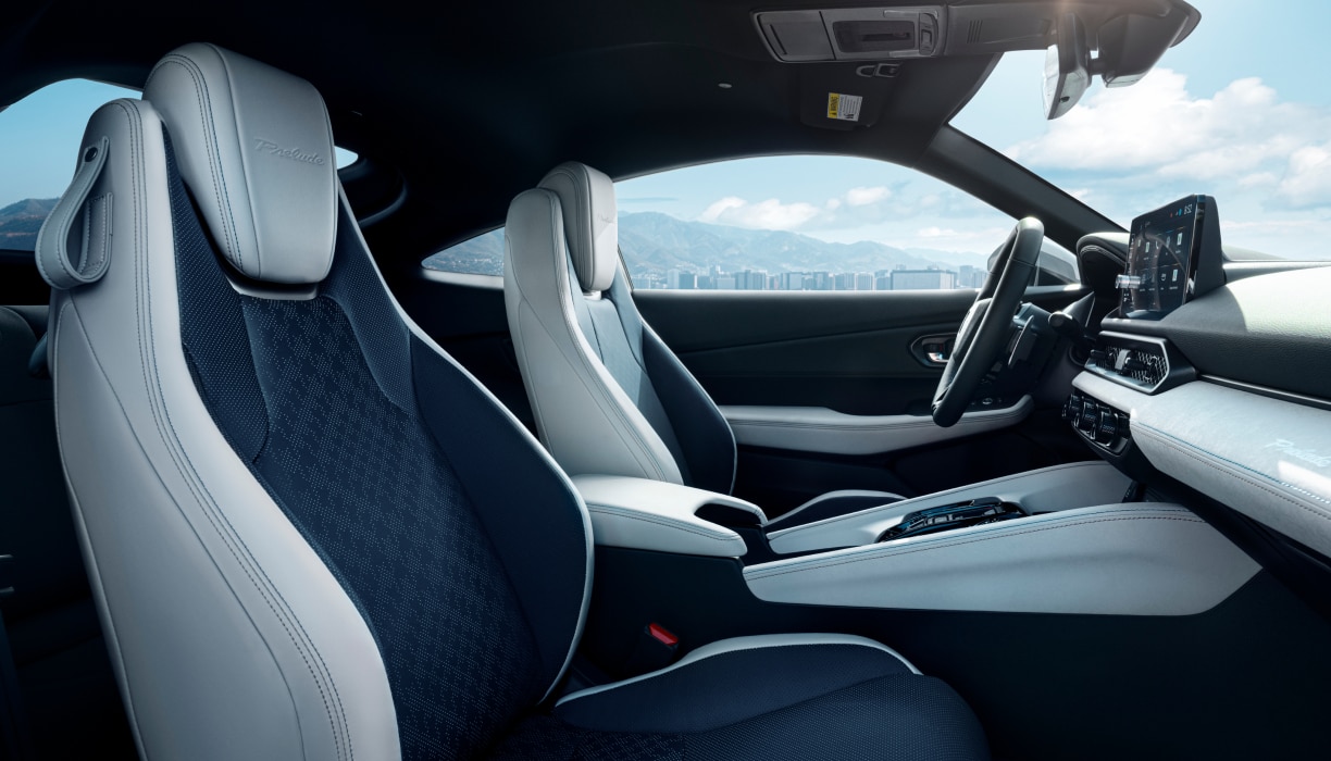 Vue du côté passager des sièges avant, du volant et du tableau de bord noir et blanc de la Prelude.