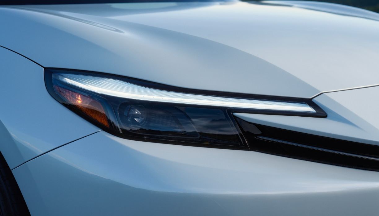 Closeup of the headlight on a White Prelude.