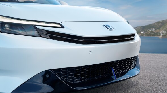 Closeup of the front of a white Prelude, showcasing the headlights. 