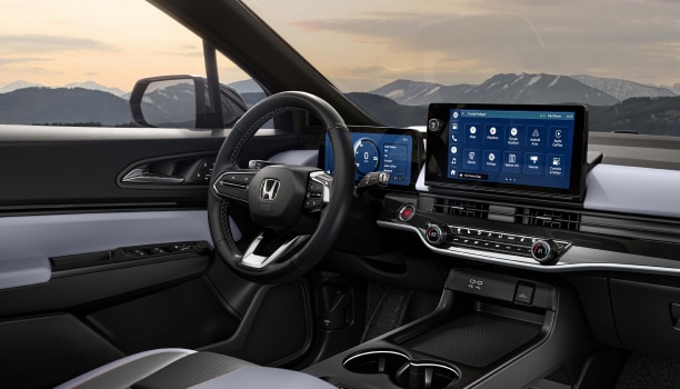3/4 panoramic interior view of dashboard and new centre console. Out the windshield we see snowy mountaintops.