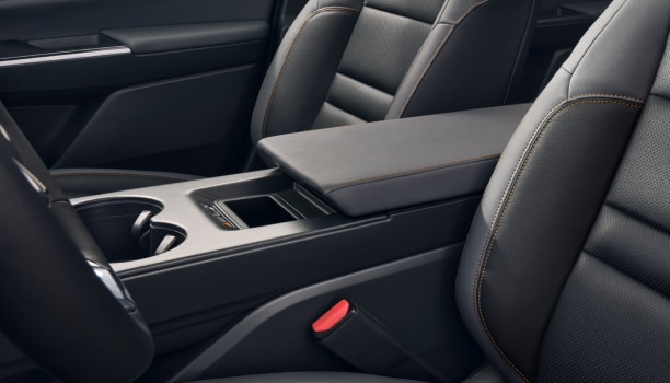 Plan de face intérieur du volant, de l’écran tactile et de la console centrale. À travers le pare-brise, nous voyons une étendue d’eau et de petits bateaux.