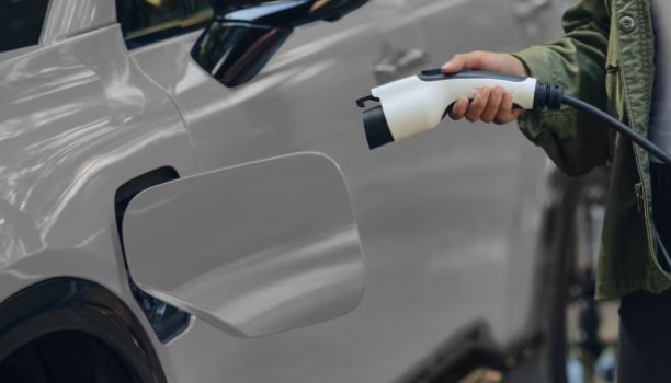 A close-up shot of a Prologue owner charging the vehicle at an electric charging station. 