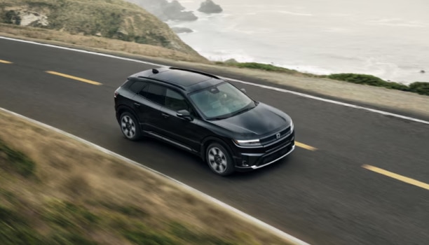 Honda Prologue noir qui roule sur une route panoramique et ouverte.