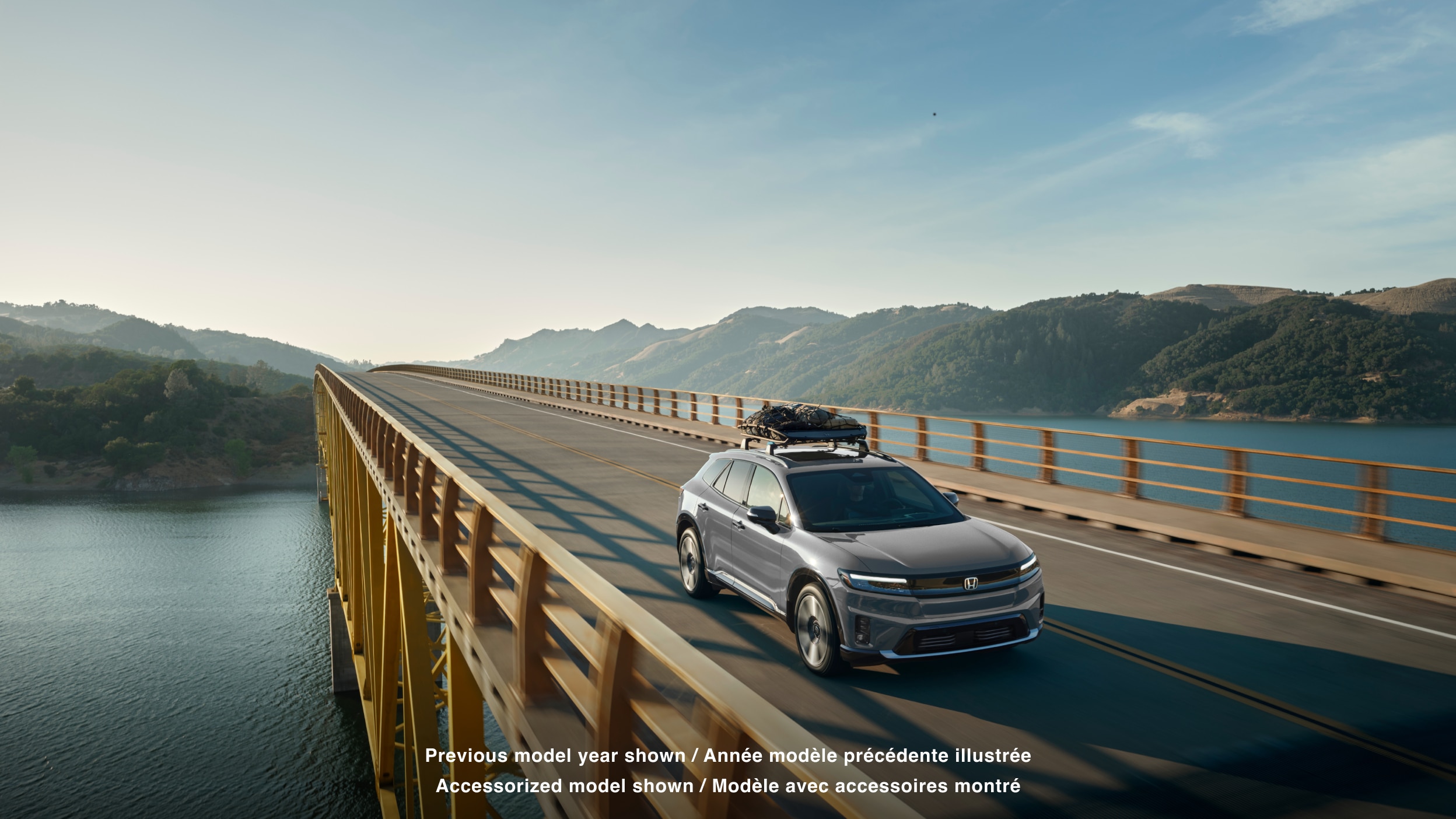 Plan large de trois quarts avant d’un Prologue circulant sur un pont avec des bagages sur la galerie de toit.