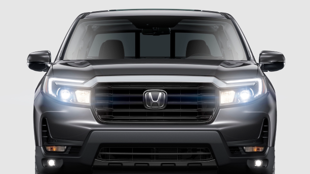 Front view of Ridgeline on white space with LED headlights on.