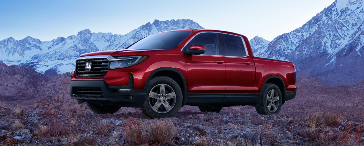 3/4 front view of red Ridgeline parked amid barren tundra.