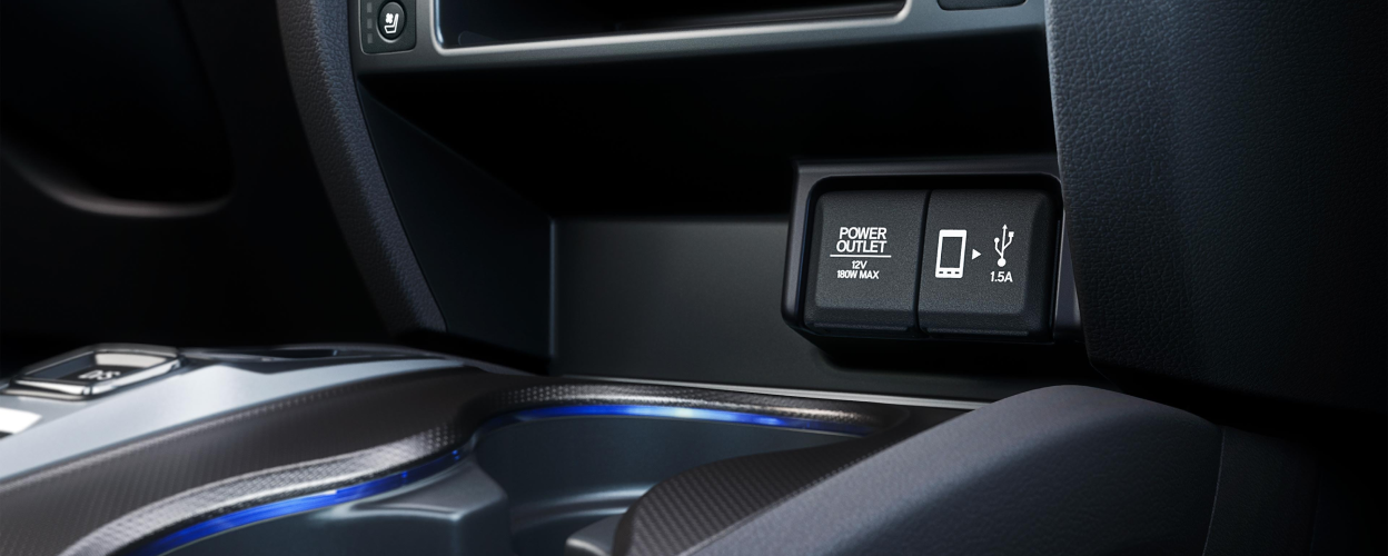 Closeup of USB ports and cupholders in centre console.