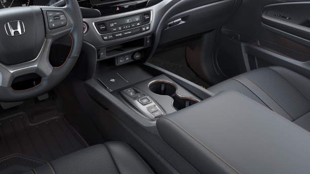 Interior medium wide shot of centre console armrest and cupholders.