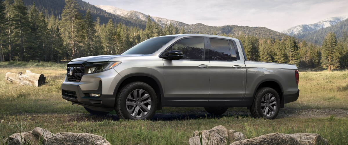 Side view of grey Ridgeline in forest.