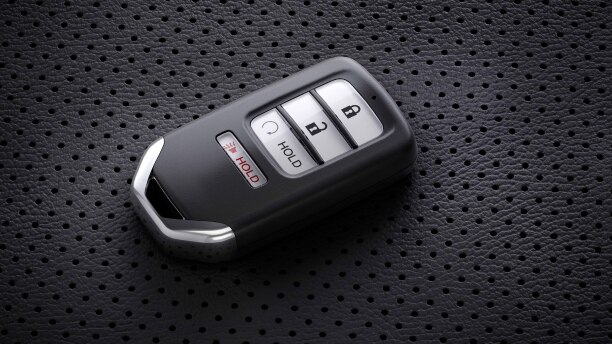 Closeup of key fob sitting on perforated seat.