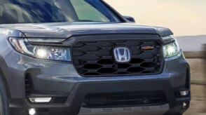 3/4 front closeup of headlights on a grey Ridgeline.