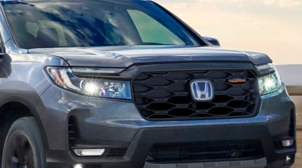 3/4 front closeup of headlights on a grey Ridgeline.