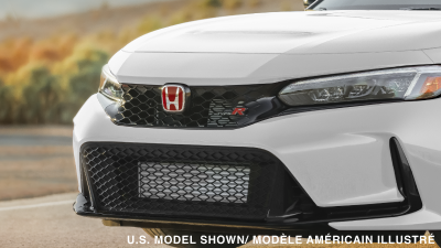 Gros plan de trois quarts d’un logo « Honda » rouge et d’un emblème « Type R » sur une Type R rouge.