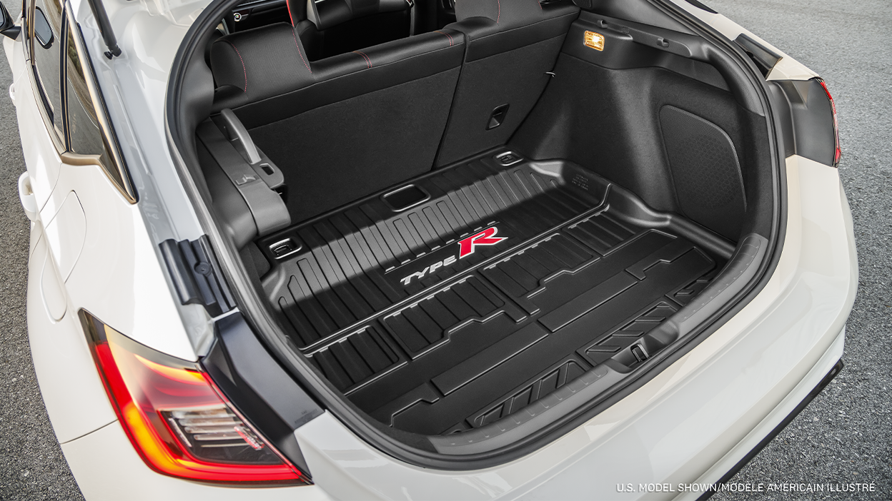 Closeup of an open trunk on a white Type R, showing the speakers and the custom-fit “Type R” branded rubber trunk mat. 