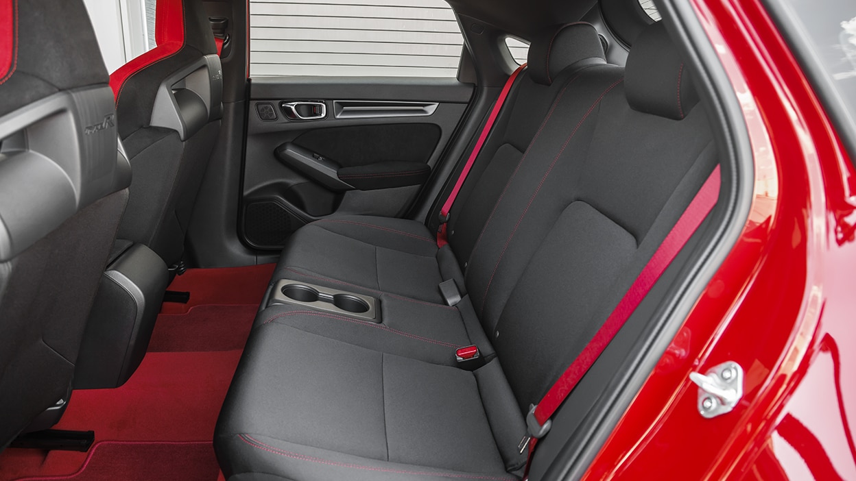 Vue latérale des sièges arrière d’une Type R rouge.