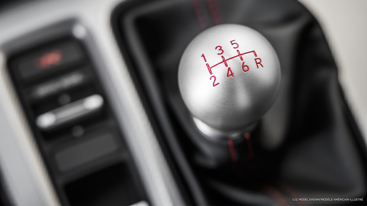 Très gros plan du haut du levier de vitesses, affichant la grille des vitesses engravées.