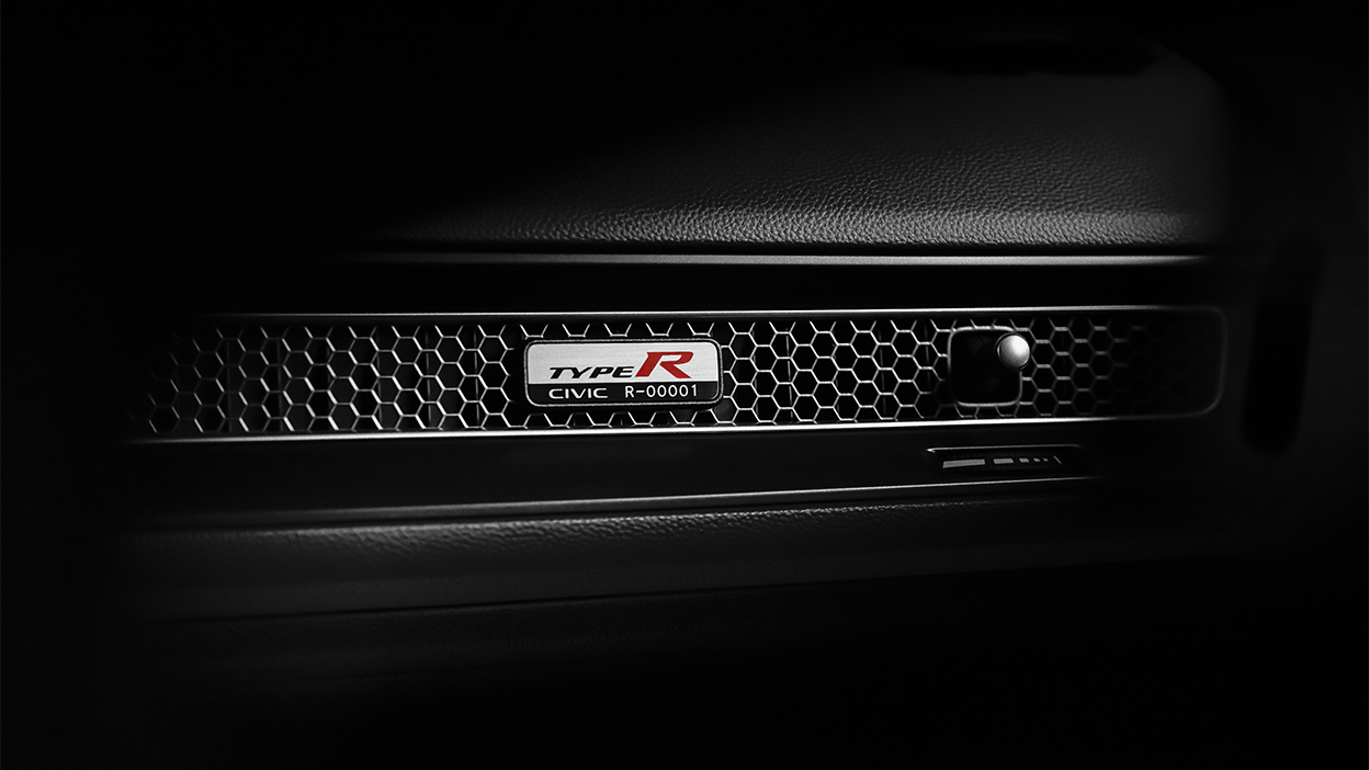 Gros plan de la plaque de numéro de série d’une Type R sur la bouche d’air alvéolée, sur le tableau de bord côté passager.