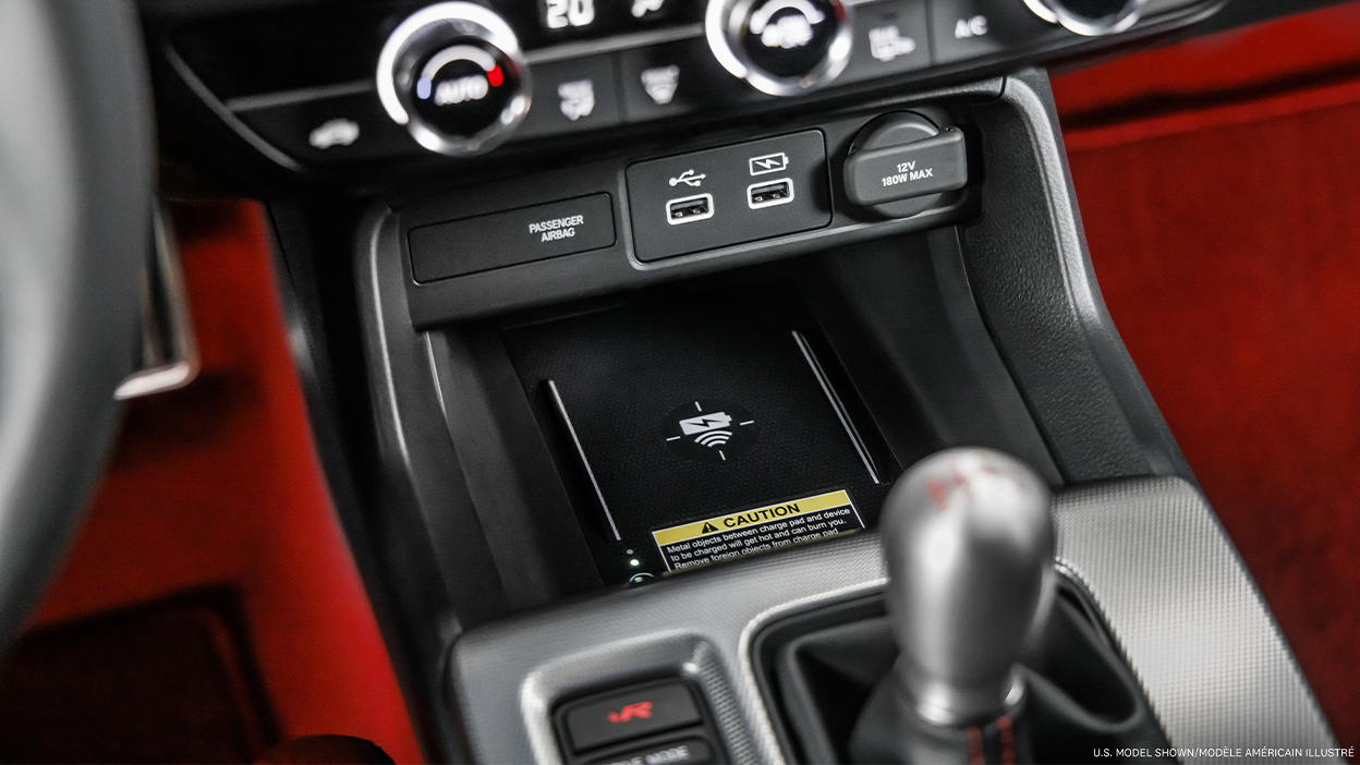 Closeup of wireless charging pad in centre console above gear shifter.