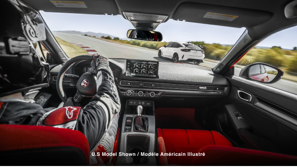 Interior shot, over pilot’s shoulder, showcasing the Type R’s cockpit as it races on a track.