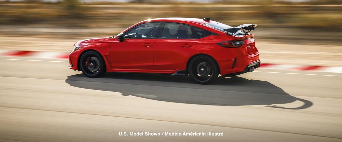 Sideview of red Type R racing on a track.