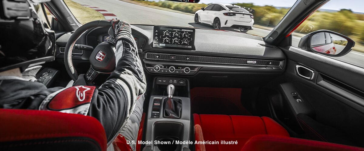 Interior shot, over pilot’s shoulder, showcasing the Type R’s cockpit as it races on a track.