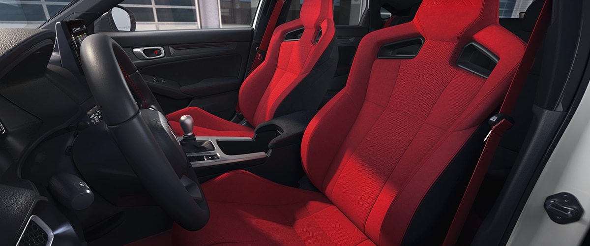 Wide shot of the two front red bucket sports seats.
