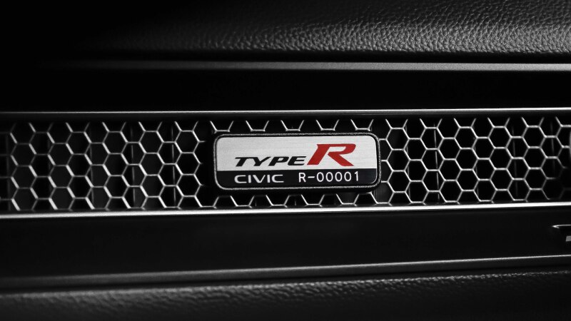 Gros plan de la plaque de numéro de série d’une Type R sur la bouche d’air alvéolée, sur le tableau de bord côté passager.